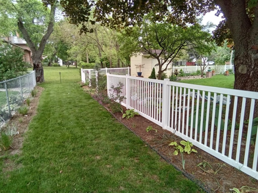 white vinyl fence with medium sized openings on a small property