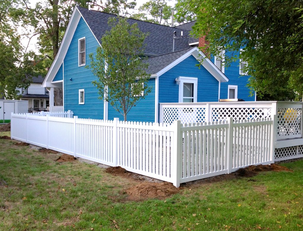 white picket fence surrounding a bright blue home