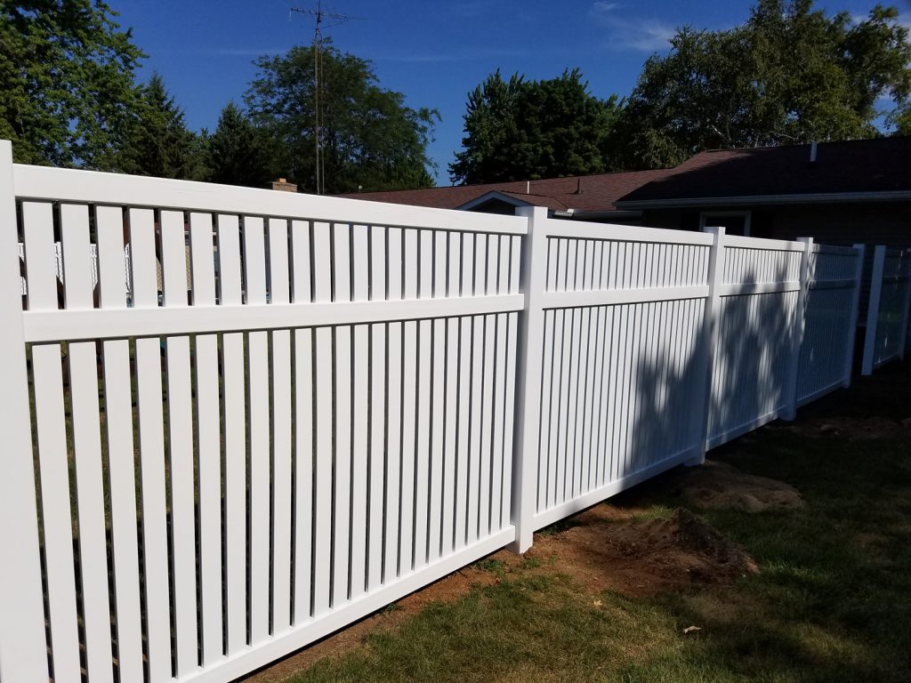 white fence on a property with the sun shining on it