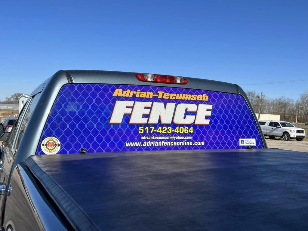 Adrian Fence logo on the back window of a pickup truck